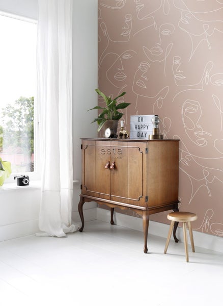 Wohnraum mit Holzschrank, Hocker und gemusterter Tapete