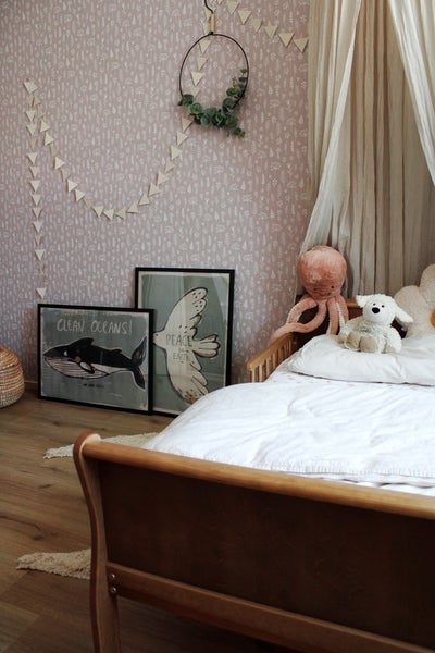 Kinderzimmer mit Holzbett, Baldachin, Kuscheltieren und Wanddekoration