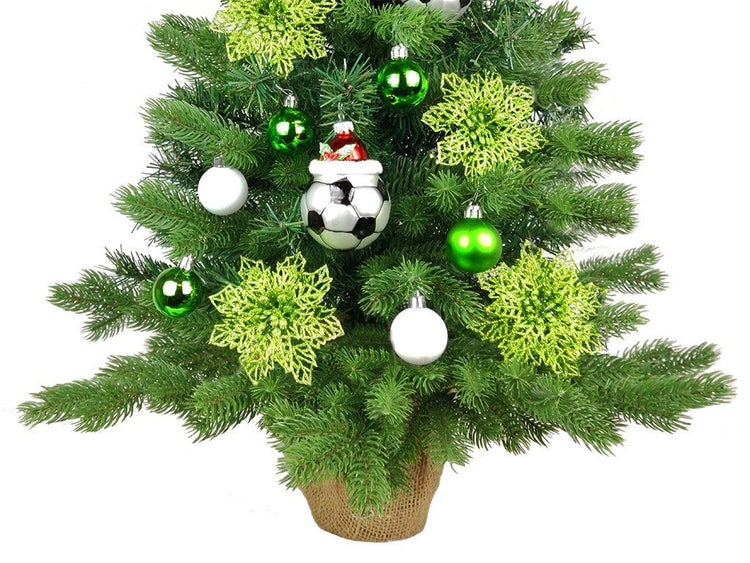 Geschmückter künstlicher Weihnachtsbaum in einem Jutesack mit Fußball und Weihnachtskugeln als Weihnachtsdekoration