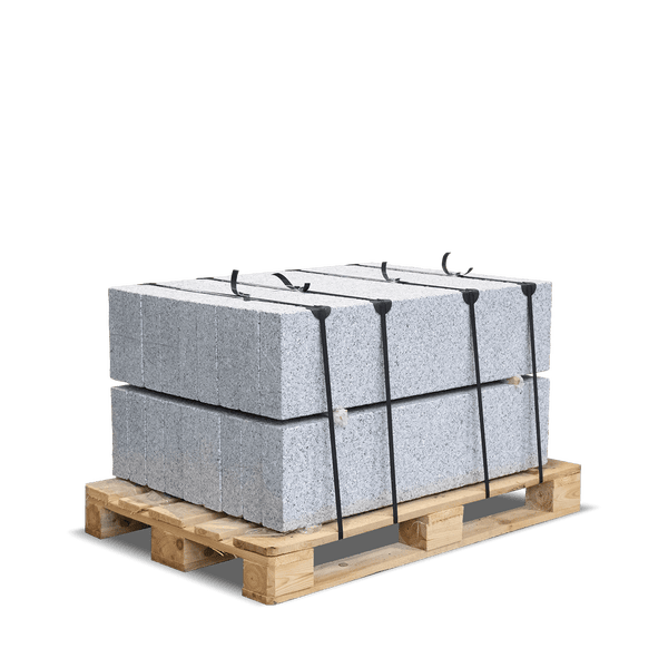 Granitsteine auf einer Holzpalette, gesichert mit schwarzen Kunststoffbändern.