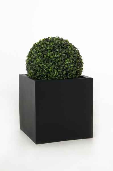 Künstlicher Buchsbaum in Kugelform in einem schwarzen quadratischen Pflanzgefäß.