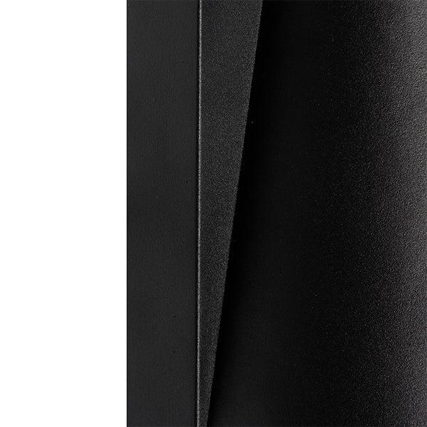 Detail einer matt-schwarzen, strukturierten Metalloberfläche mit eckigen und gewölbten Formen.