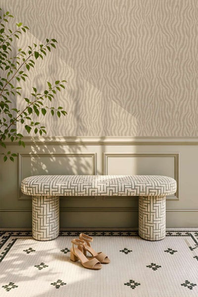Wohnraum mit Tapete mit Wellenmuster, einer Sitzbank mit geometrischem Muster und einem Fliesenboden mit Mosaikmuster.