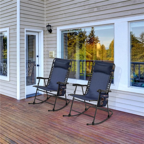 Zwei dunkelblaue Garten-Schaukelstühle mit Kopfkissen und Seitentaschen auf einer Holzterrasse vor einem Wohnhaus.