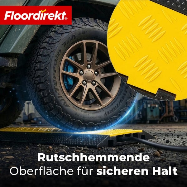 Floordirekt Logo. Kabelbrücke mit rutschhemmender Profiloberfläche, über die ein Autoreifen fährt, während ein Kabel geschützt wird.
