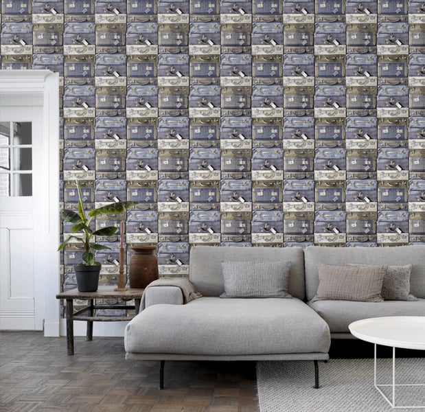Wohnzimmer mit grauer Couch und Tapete mit Koffer Motiv