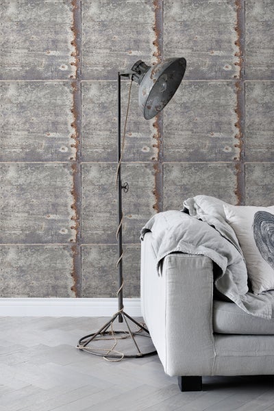 Raumansicht mit grauer Tapete in Metallplattenoptik, Stehlampe und Sofa