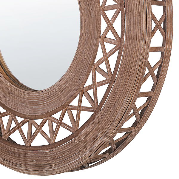 Detailansicht eines runden Wandspiegels mit einem Rahmen aus geflochtenem Rattan und dekorativem Durchbruchmuster.