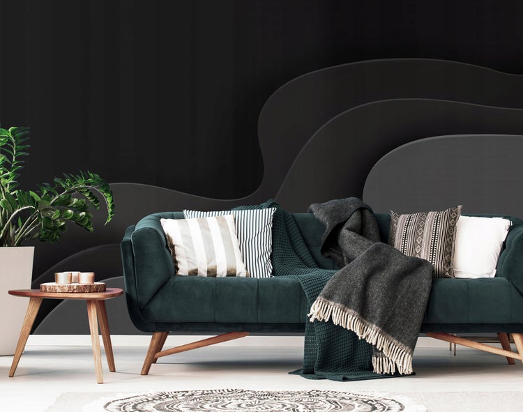 Wohnzimmer mit Sofa, Kissen, Decken und Beistelltisch vor einer Wandgestaltung