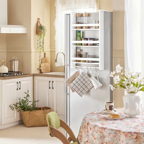 Helle Küche mit weißem Kühlschrank, Gewürzregal, Küchentisch und Dekorationen