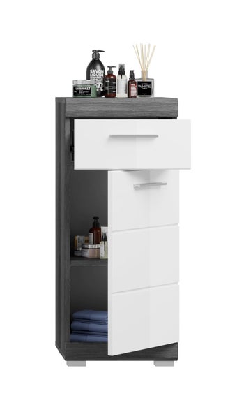 Schmaler Badezimmerschrank mit Korpus in dunkler Holzoptik, glänzend weißer Schublade und Tür sowie silbernen Griffen.