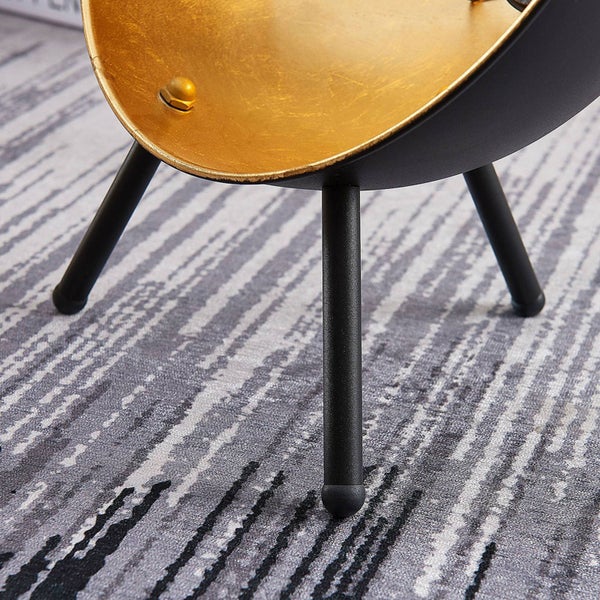 Detailaufnahme eines Tischbeins mit goldfarbener Tischplatte