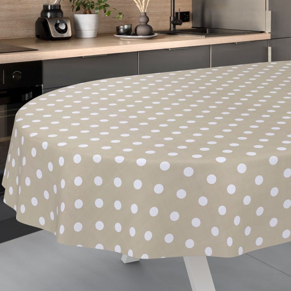 Ovale, beige Tischdecke mit großen weißen Punkten in einer modernen Küche mit Holzarbeitsplatte.
