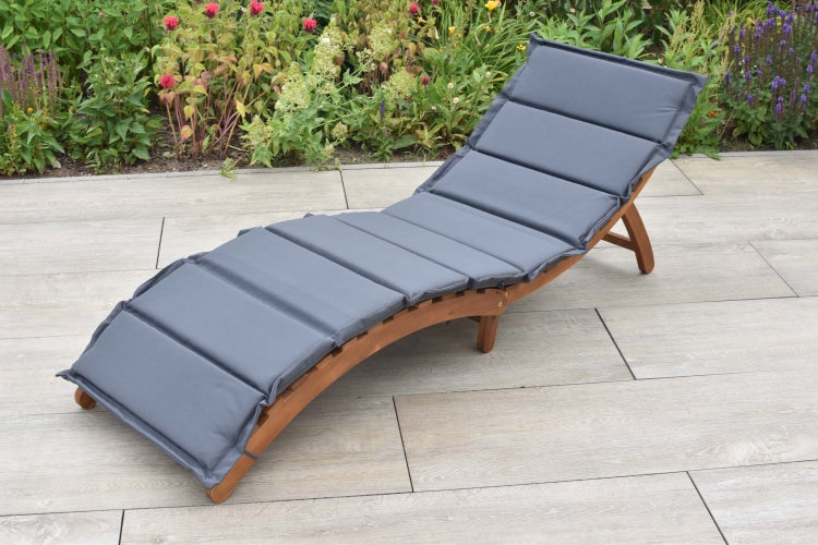 Gartenliege aus Holz mit grauer Auflage auf einer Terrasse
