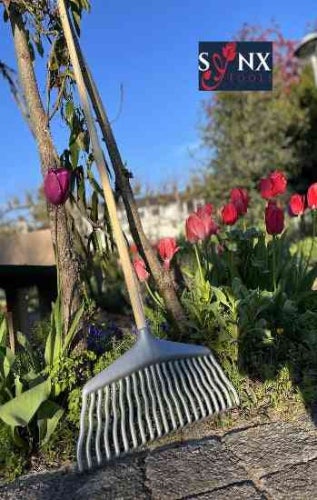 Gartenaufnahme mit einem Laubbesen und dem Sonxtool Logo.
