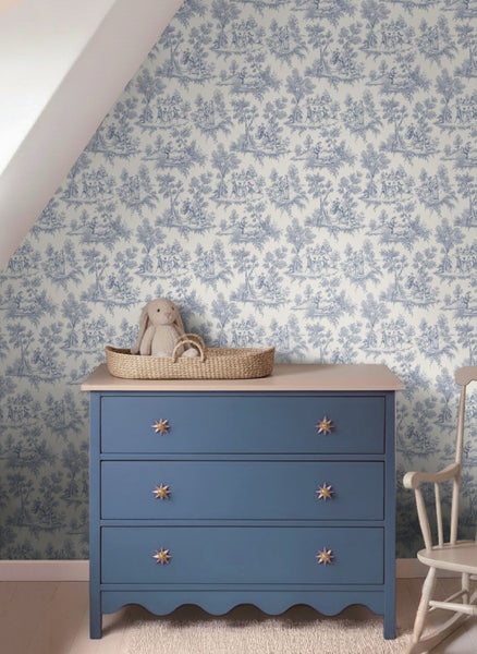 Vliestapete mit Toile-de-Jouy-Muster in Blau und Weiß in einem Kinderzimmer mit blauer Kommode und Stoffhase.