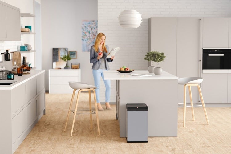 Moderne Küche mit Kücheninsel und einem rechteckigen Sensor Mülleimer aus Metall, der vor der Kücheninsel steht.