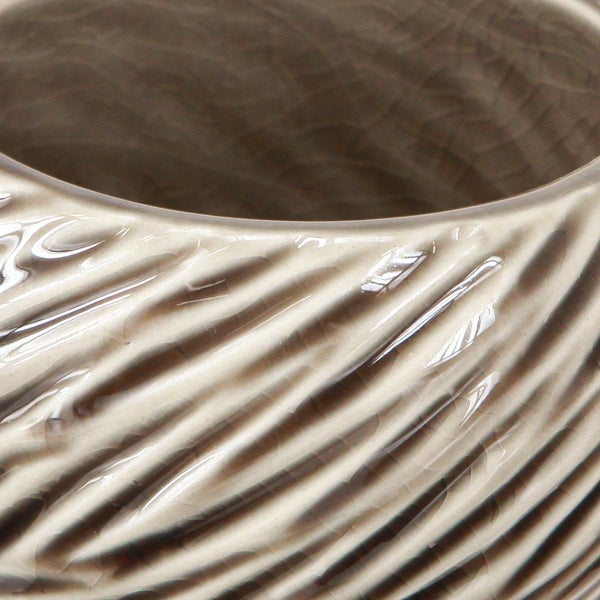 Nahaufnahme einer beigen Keramikvase mit gerippter Textur.