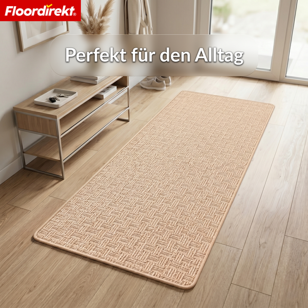 Floordirekt Logo. Rechteckiger Teppichläufer mit gewebter Struktur in einem hellen Flur mit Holzfußboden und einem Holzregal.