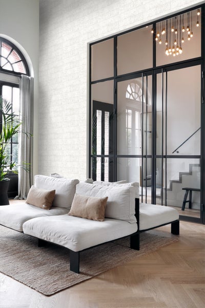 Heller Wohnraum mit Couchgarnitur, Teppich und gemusterter Tapete