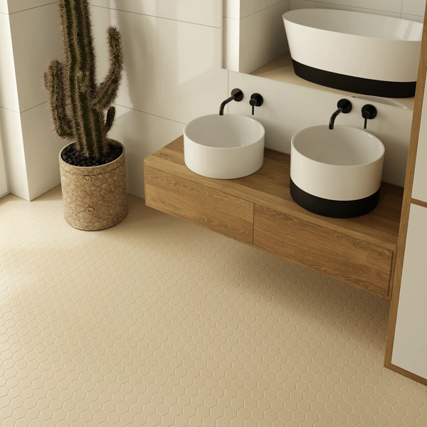 Modernes Badezimmer mit zwei runden Aufsatzwaschbecken auf schwebendem Holz-Waschtisch, schwarzen Armaturen, Sechseckfliesen und Kaktus.