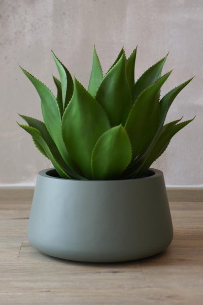 Künstliche Agave im grauen Topf, grüne Kunstpflanze mit gezackten Blatträndern für die Innendekoration.