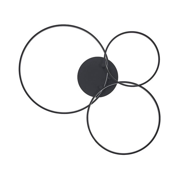 Moderne LED-Deckenleuchte mit drei schwarzen, sich überschneidenden Ringen an einer Zimmerdecke über einem Bücherregal.