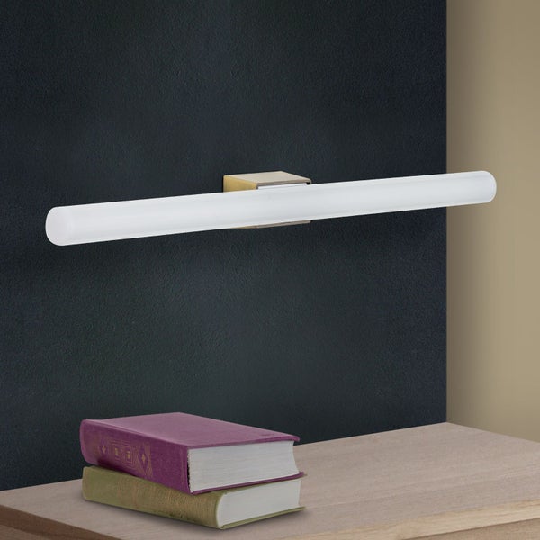 Moderne LED Wandleuchte in länglicher Form mit metallischem Halter montiert an einer Wand über einem Tisch mit zwei Büchern
