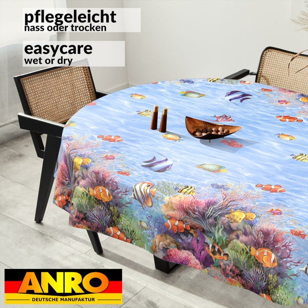 Pflegeleichte runde Tischdecke mit Unterwassermotiv, Korallenriff und bunten Fischen auf einem Esstisch. ANRO Logo.