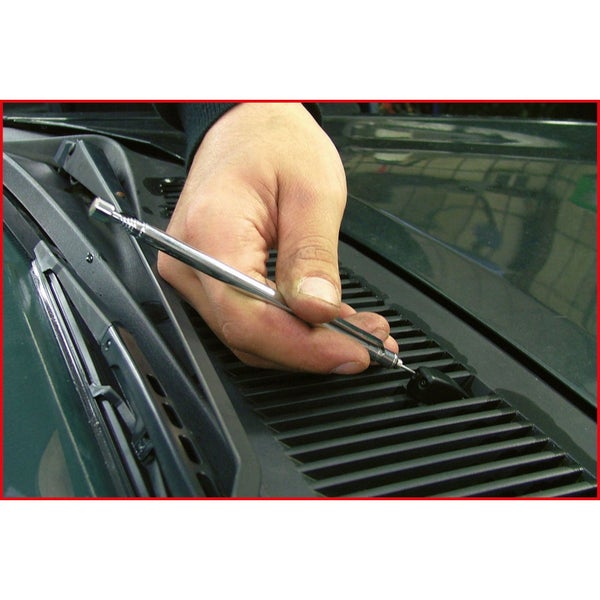 Eine Person schneidet mit einer Blechschere ein Blech.