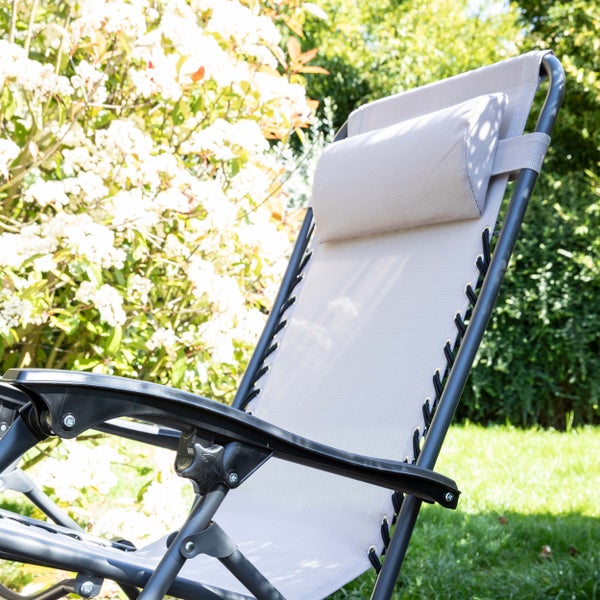 Garten-Relaxsessel mit verstellbarem Kopfpolster und Armlehnen in heller Gartenumgebung.