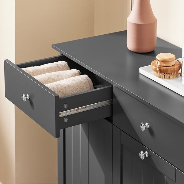 Grauer Badezimmerschrank mit offener Schublade und Handtüchern