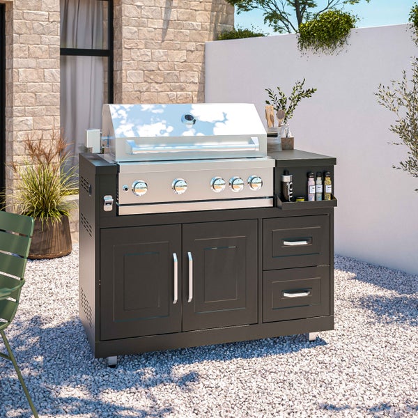 Moderner Gasgrill aus Edelstahl mit schwarzem Unterschrank, Türen und Schubladen in einer Außenküche auf Kiesoberfläche.