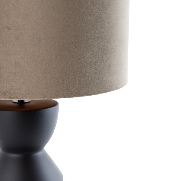 Detailansicht einer Tischlampe mit Stoffschirm und dunklem Lampenfuß