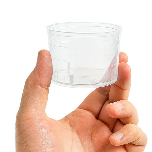 Messbecher aus Kunststoff in Hand gehalten
