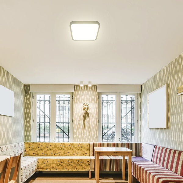 Wohnraum mit Deckenleuchte, Sitzgruppe und Fenstern