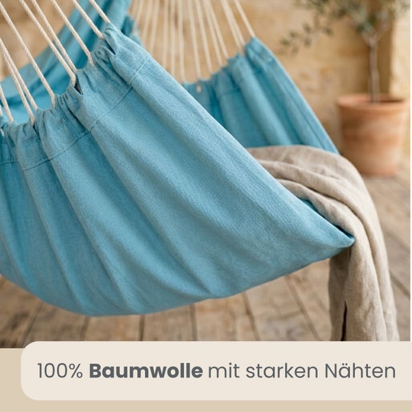Blauer Hängesessel aus einhundert Prozent Baumwolle mit stabilen Nähten und einer Decke auf einer Terrasse.