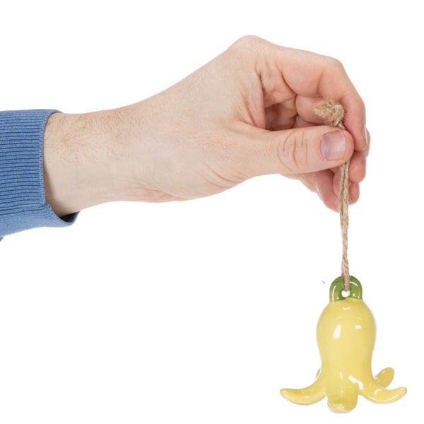 Hand hält gelbe Glockenblume aus Keramik mit Juteseil zur Dekoration