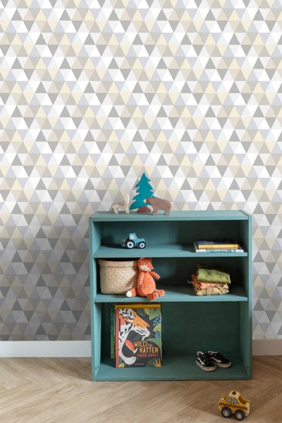 Dekoratives Kinderzimmerregal mit Spielzeug und Buch vor einer geometrischen Tapete