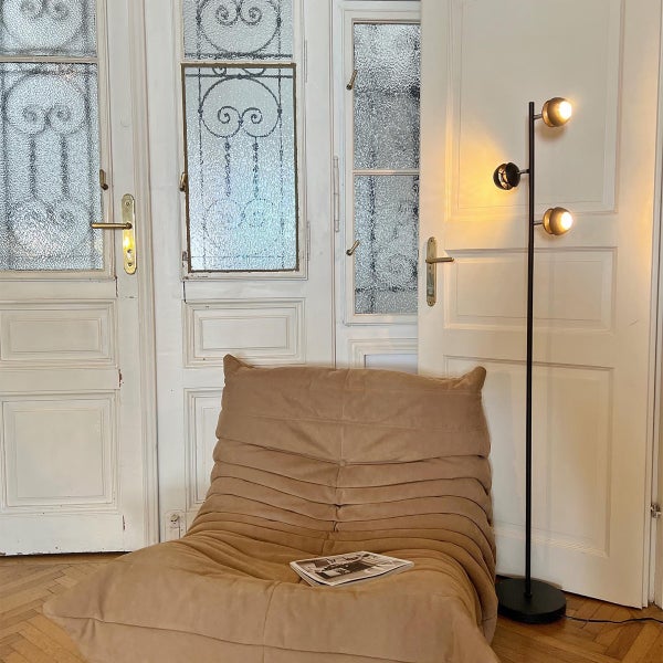 Interieuransicht mit Sessel, Stehlampe und Flügeltüren