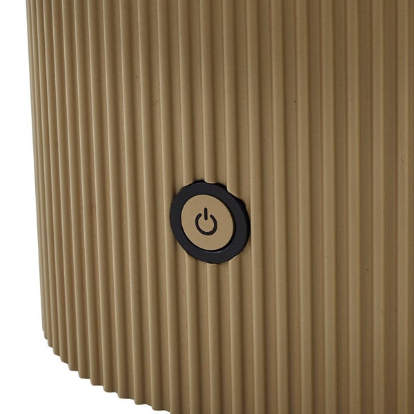 Nahaufnahme eines runden Ein- und Ausschalters an einem Produkt mit vertikaler Rippenstruktur.