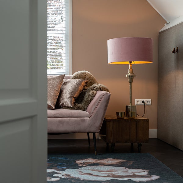 Wohnzimmer-Szene mit Sofa, Kissen, Teppich, Lampe und Beistelltisch