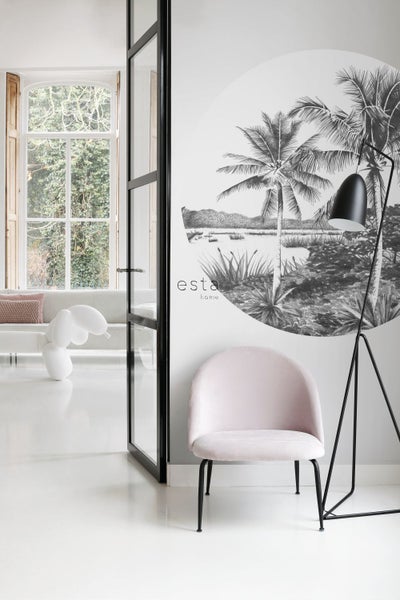 Wohnzimmer mit Sessel, Stehlampe und Wandbild mit tropischem Motiv