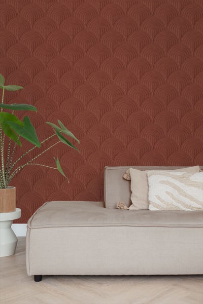 Wohnzimmer mit rot gemusterter Tapete, Sofa und Zimmerpflanze