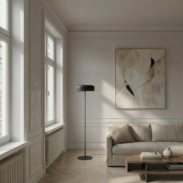 Wohnzimmer mit Sofa, Tisch, Stehlampe und Kunstwerk