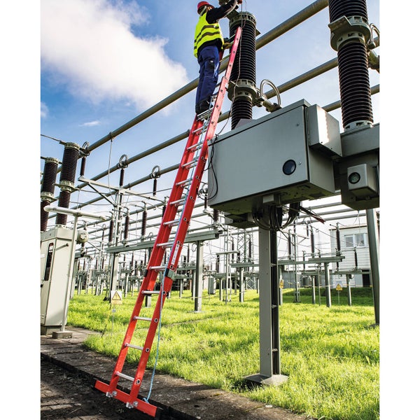 Mann auf einer roten Leiter bei Wartungsarbeiten an einer elektrischen Anlage.