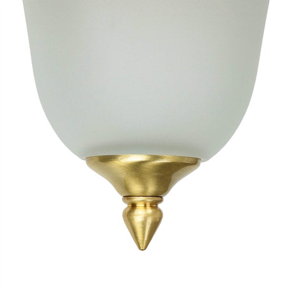 Detailansicht einer Lampe mit Glasschirm und goldfarbenem Aufsatz