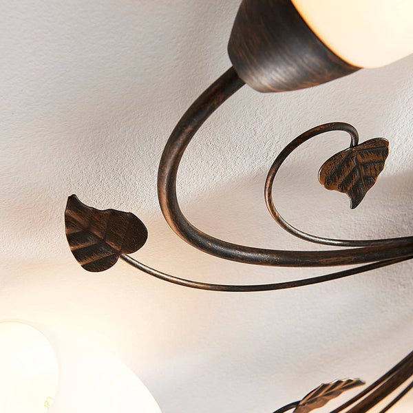 Detailansicht einer Deckenleuchte mit floralem Design und Glühbirnen.