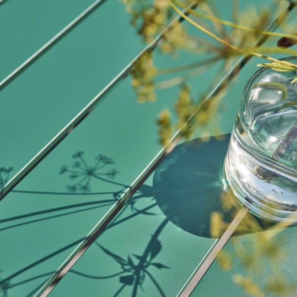 Rechteckiger grüner Metall-Gartentisch mit Lattenoberfläche und vier runden Beinen.