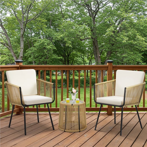 Gartenmöbel-Set mit zwei Sesseln aus Seilgeflecht, hellen Polstern und rundem Beistelltisch auf einer Holzterrasse mit Blick in den Garten.